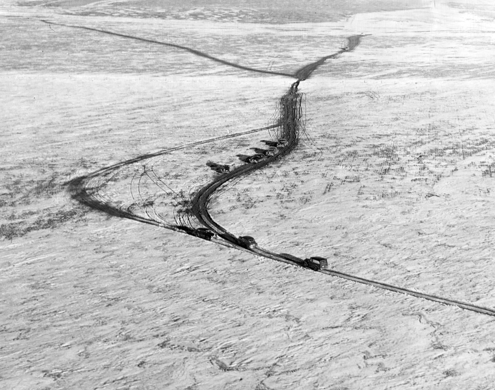 The main highway is not apparent in this photo of cars winding across the plains north of the road block on Highway 30, five miles west of Brule. Many of the cars headed west apparently got through to Big Springs by taking off through the fields for a distance of about 9 miles. Published Jan. 8, 1949.
